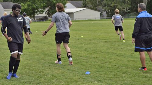 Keith Utsey (left), VPCC Men's Soccer coach Kevin Darcy (right), and the Men's Soccer team during practice