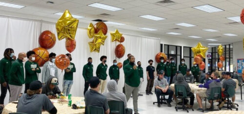 College Celebrates Basketball Team's Championship Season Coach Chris Moore (speaking) and the men's basketball team at the annual sports awards gathering