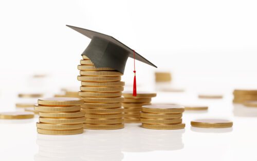 Stack Of Coins and a Black Mortarboard on White Background - Education and Savings Concept