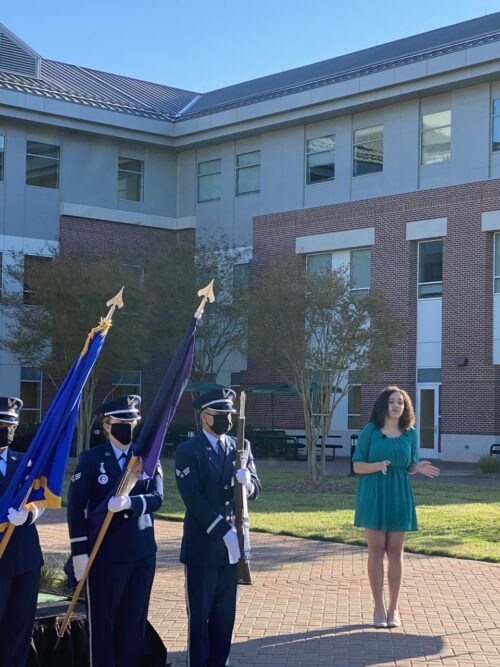 Kaya O'Brien-James singing the National Anthem with soldiers