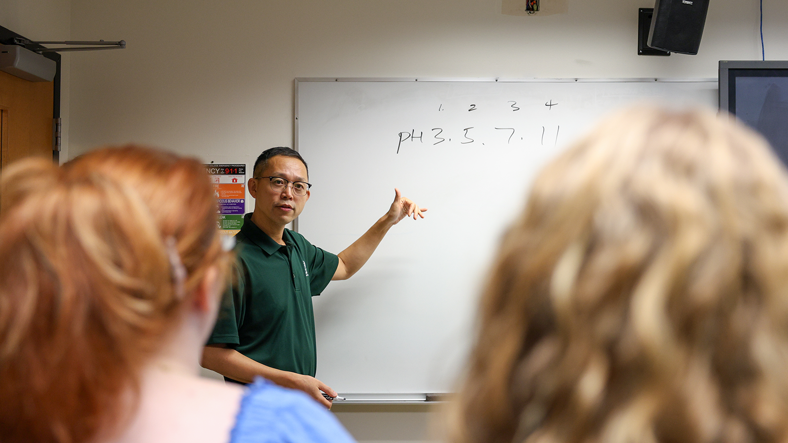 Featured image for the page. Image of biology professor Dr. Song in front of his class and teaching.