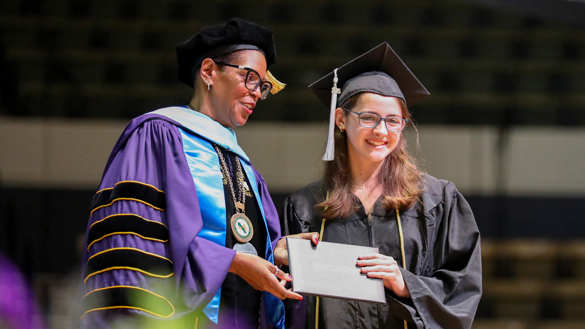 Dr. Towuanna Porter Brannon president of Virginia Peninsula Community College posing with a graduating student holding a diploma