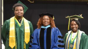 Kameron Mann (left) and Kaela Jordan (right) were all smiles at their high school graduation in early June. With them is executive principal Dr. Tanya Howard.