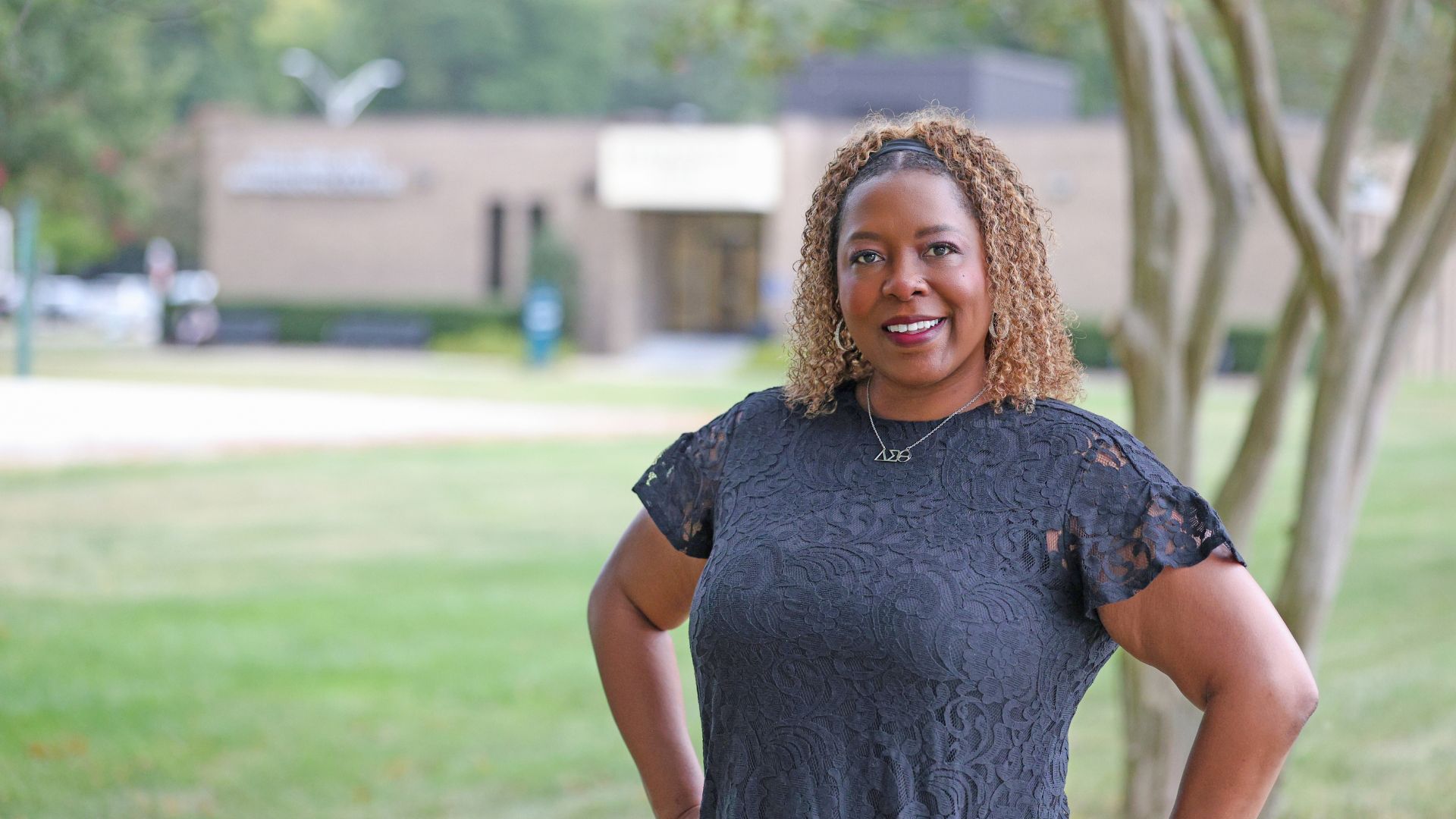 Smiling woman wearing black standing near building